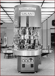 Gigant auf der Interpack 1964: Sprühdosenabfüllmaschine für Doppelschritt-Rundtakt